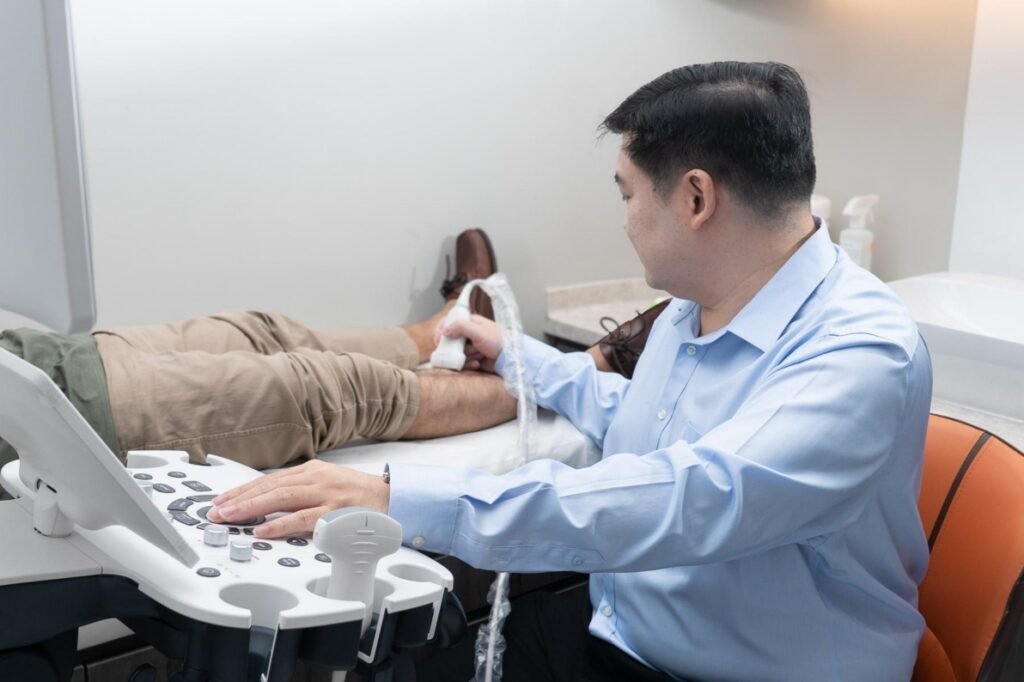 Dr Tay Jia Sheng performing a vascular ultrasound assessment on a patient's leg at Spectrum Vascular and General Surgery