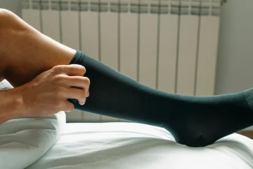 Male runner wearing compression socks while running on a street.